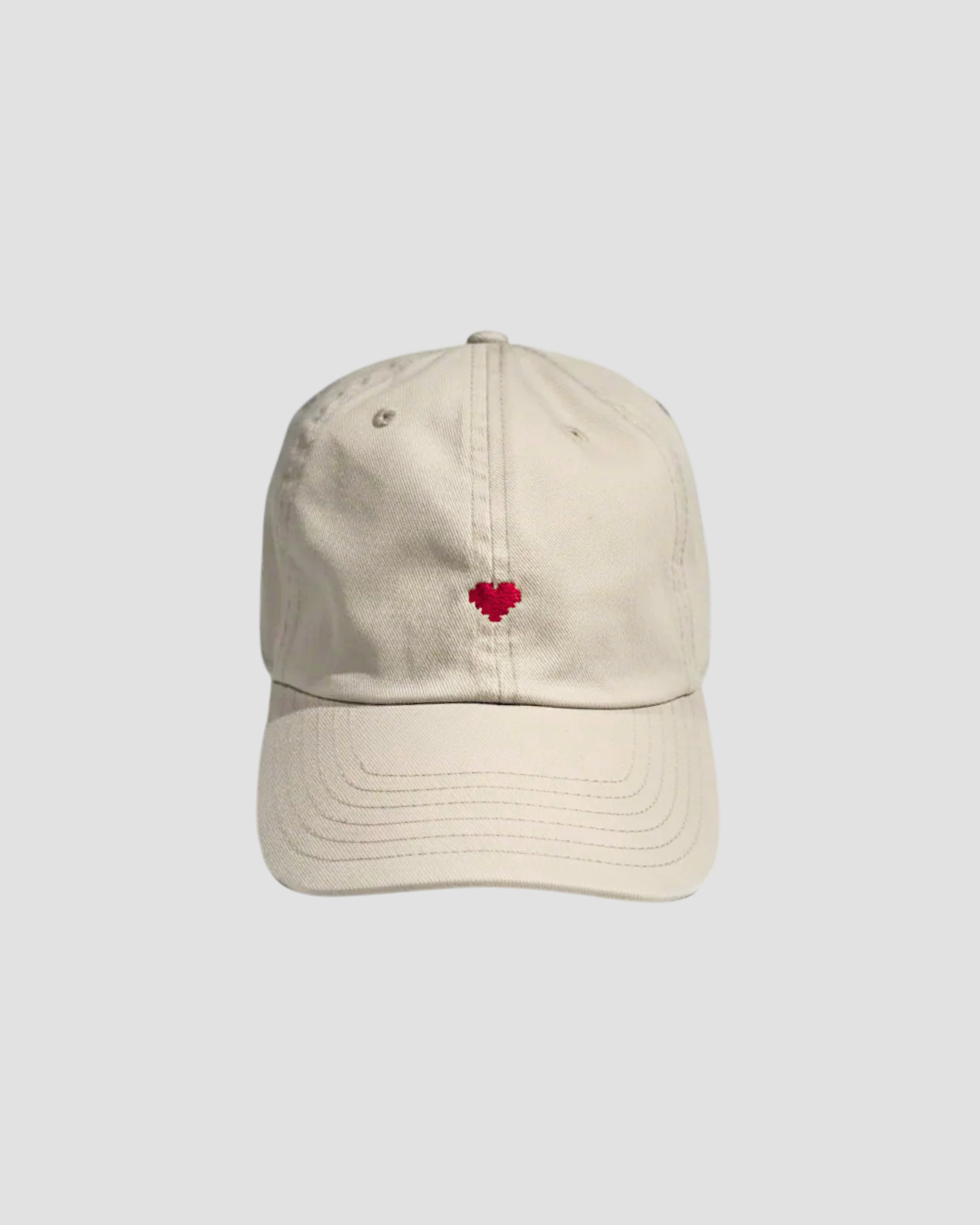 Beige cap with a red heart emblem on a white background